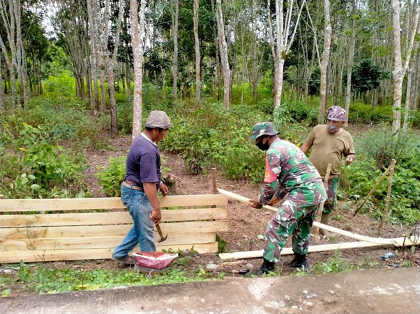Anggota Satgas TMMD Memotong Papan dan Cerucuk