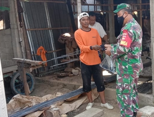 Sertu Jumroni Membagikan Masker Kepada Warga